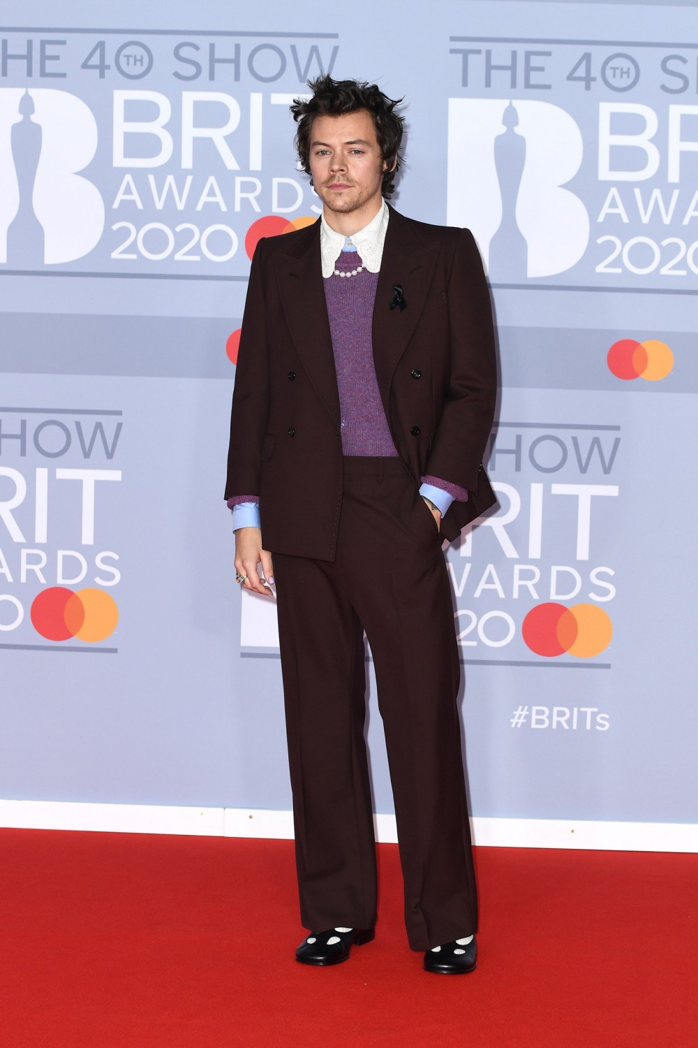 Image may contain Harry Styles Clothing Apparel Suit Coat Overcoat Fashion Human Person Premiere and Tie