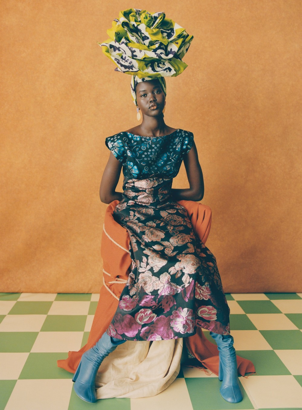 Model Adut Akech sits pretty in a manypatterned Duro Olowu dress  and uptothere gele or head tie. Octave Jewelry...